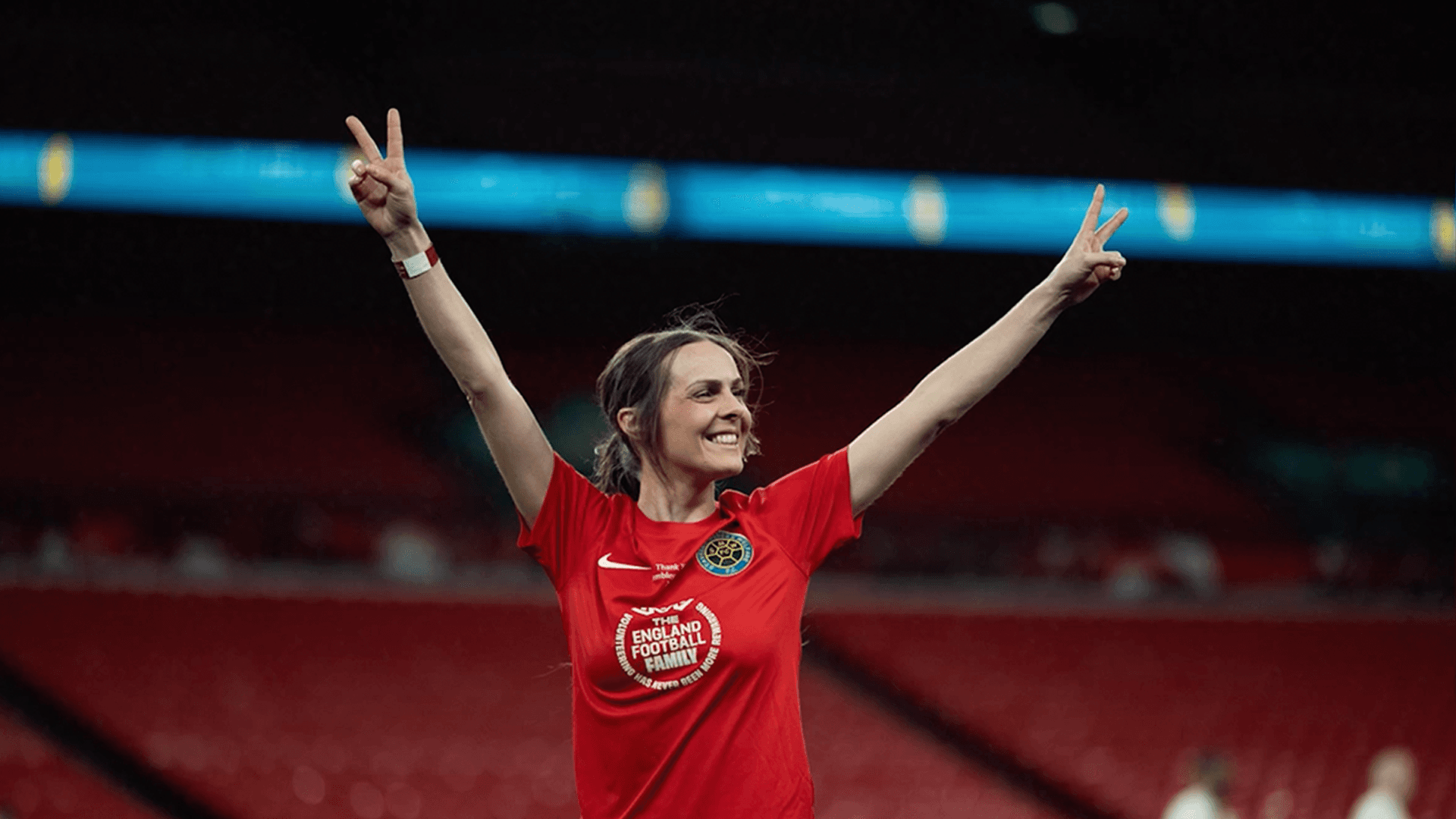 The FA Play on the Pitch video production - woman celebrating in England Football Family shirt at Wembley Stadium